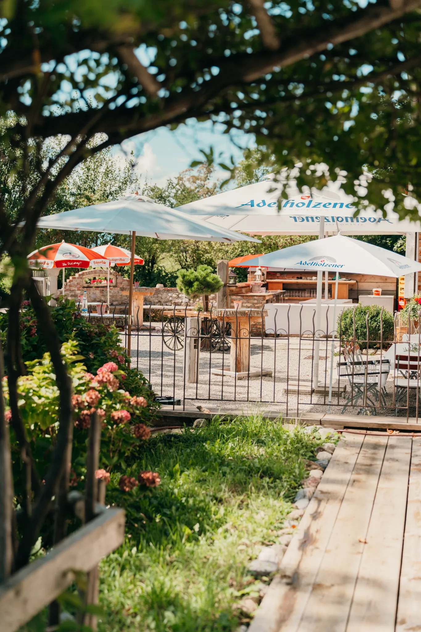 Garten und Terrasse des Pitzlloch mit Sonnenschirmen
