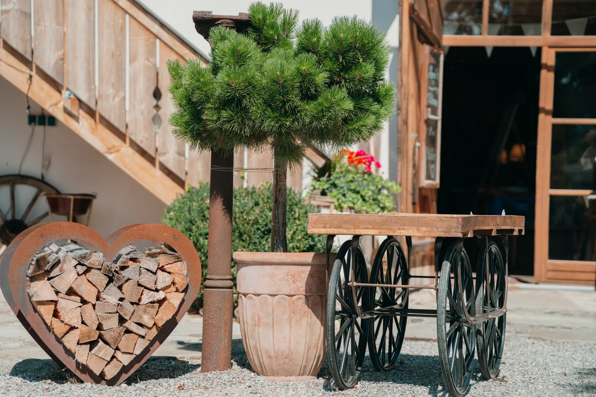 Deko-Herz aus Brennholz und Holzwagen im Außenbereich