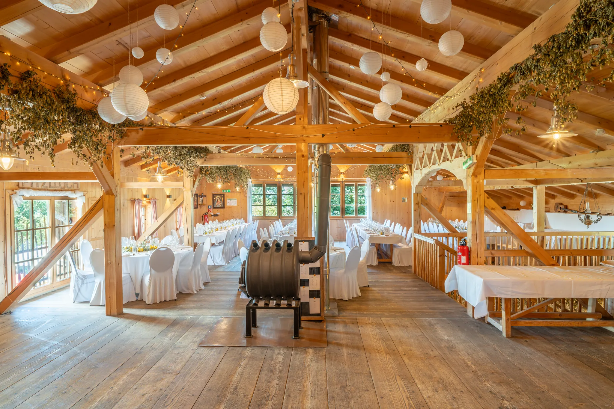Der Festsaal des Pitzlloch mit offenem Holzdachstuhl und Lichtern