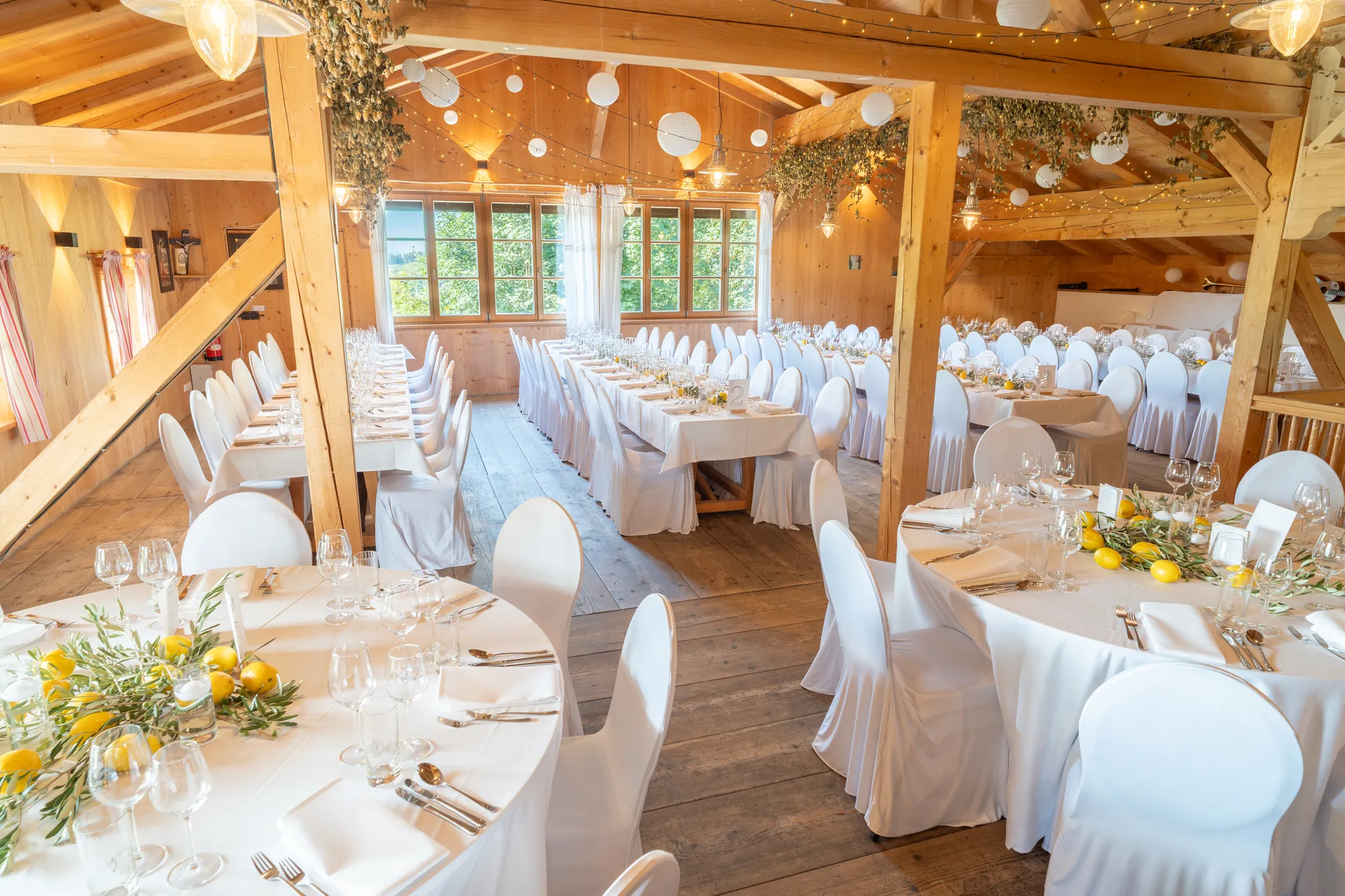 Lange Festtafel mit weißen Stuhlhussen im Festsaal des Pitzlloch